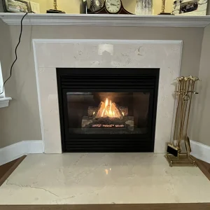 Repaired gas fireplace in Hampton, VA with clean glass, steady flame, and newly arranged gas log set.