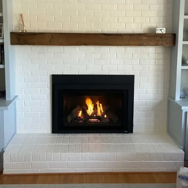 Majestic direct vent fireplace insert installed in a remodeled white brick fireplace